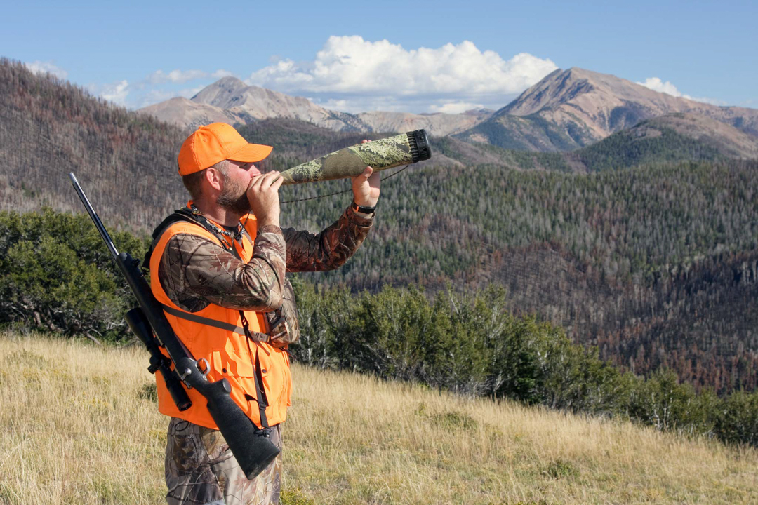 Hunter blowing an elk bugle on a western big game hunt